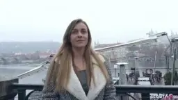 Junges blondes Teen mit langen Haaren und unschuldigem Blick steht auf einer Brücke über dem Fluss